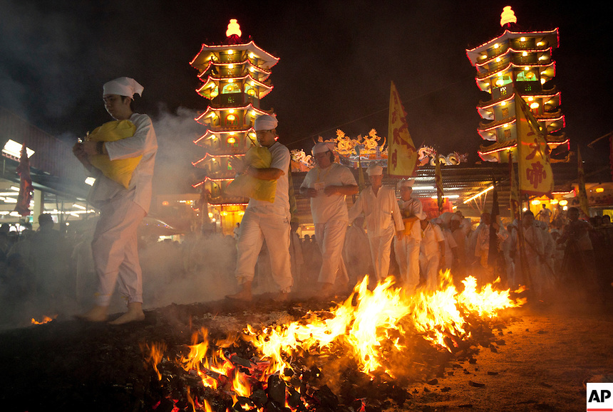 Malaysian ethnic Chinese walk barefoot over burning coals on the final day of the Nine Emperor Gods festival at a temple in Kuala Lumpur, Malaysia, Wednesday, Oct. 5, 2011. The men have abstained from meat for the past nine days in order to purify their bodies in preparation for this painful ritual, in which women are barred from participating. (AP Photo/Vincent Thian)
