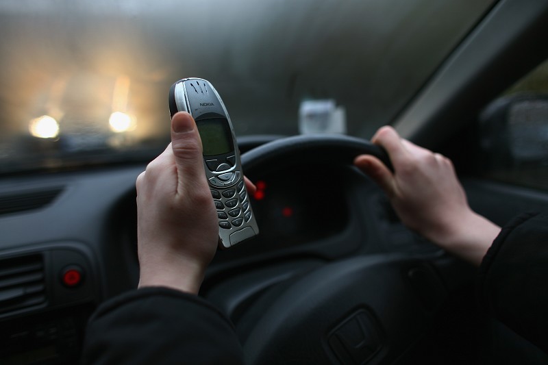 GLASGOW, UNITED KINGDOM - FEBRUARY 27: In this photo illustration a woman uses her mobile phone February 27, 2007 in Glasgow, Scotland. Drivers who use hand-held mobile phones while driving will now face fixed penalty fine of GBP60 and three penalty points on their driving licence. (Photo by Jeff J Mitchell/Getty Images)