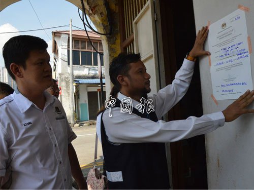 王耶宗（左起）陪同卫生局官员，在酱油厂大门贴上关厂2星期的告示。